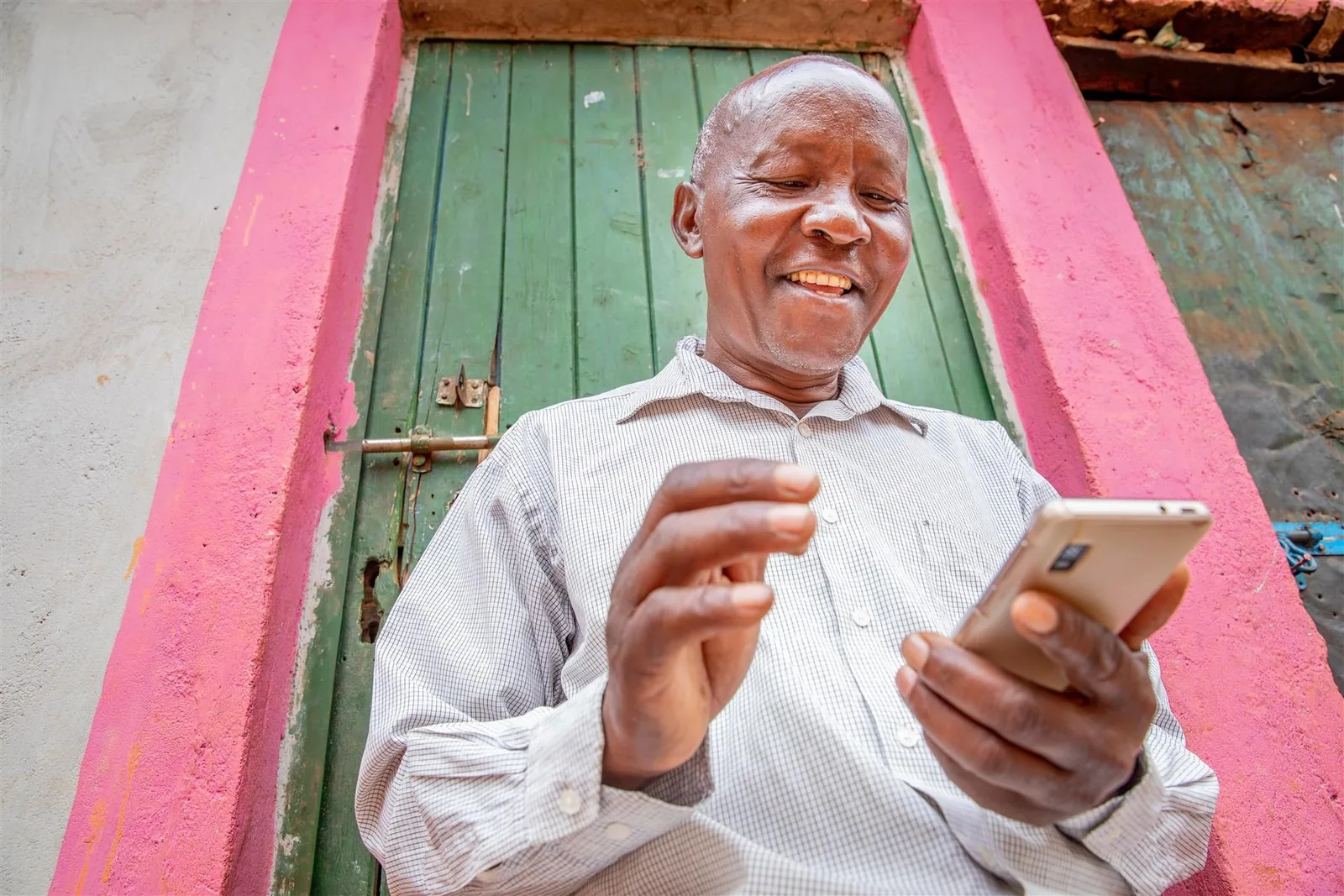 Farmer checking a smartphone outdoors.